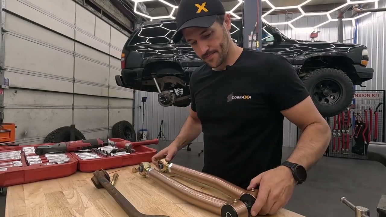 Matching the adjustable rear upper control arm lengths on the workbench by mirroring the arms and aligning the joints with a bolt