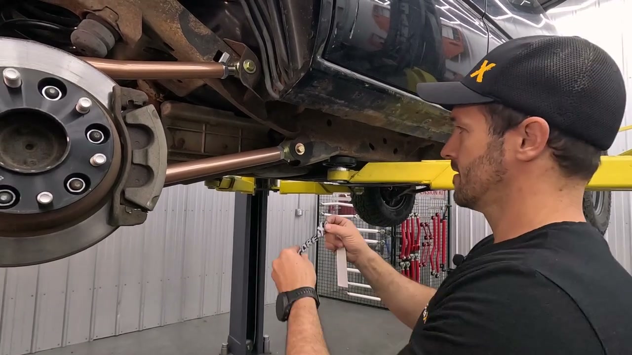 New Camp Series adjustable control arm installed on the Chevy Tahoe rear axle next to the brake rotor