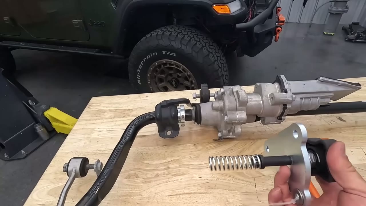 Close-up of the EVO manual knob and spring next to the Rubicon sway bar actuator housing on the workbench