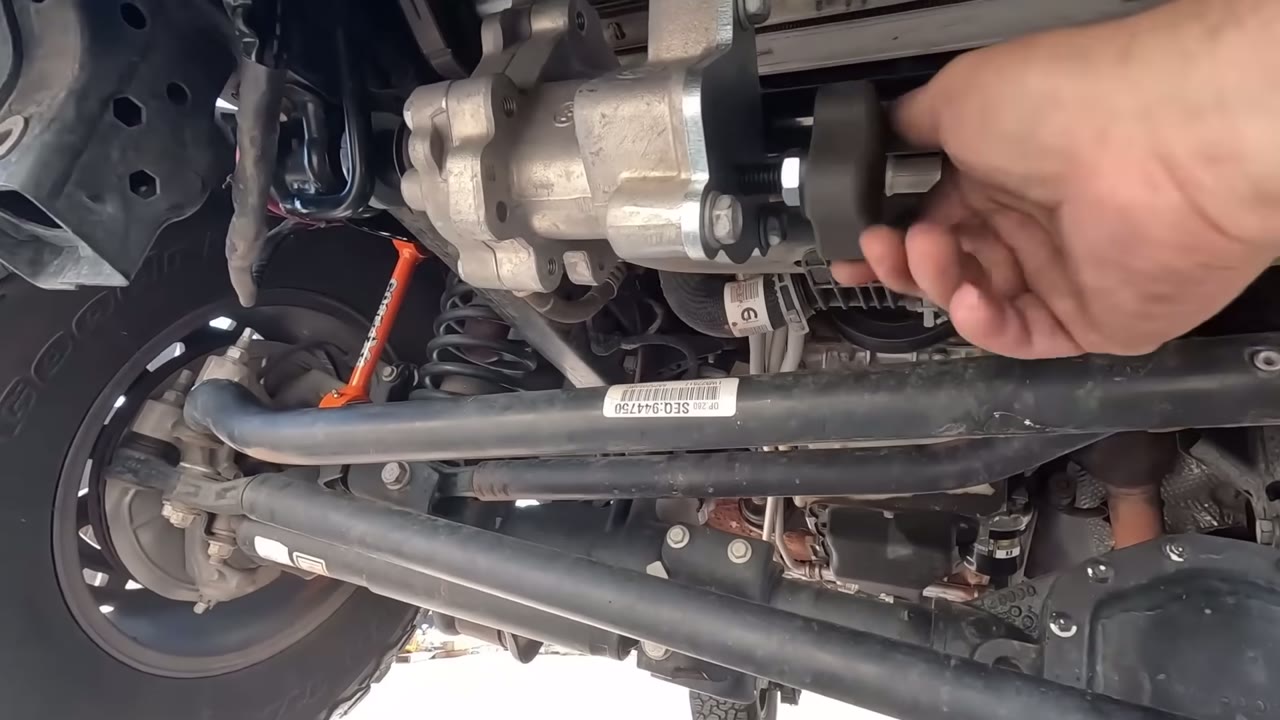 Hand operating the EVO manual disconnect knob on the installed Rubicon sway bar under the JL Wrangler
